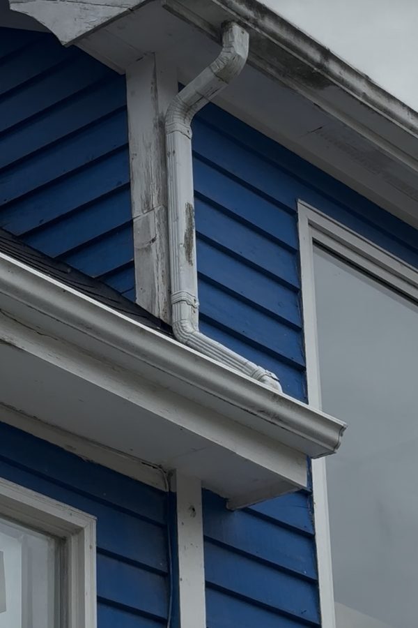 Downspout and fascia at Pier One before cleaning, streaked with grime