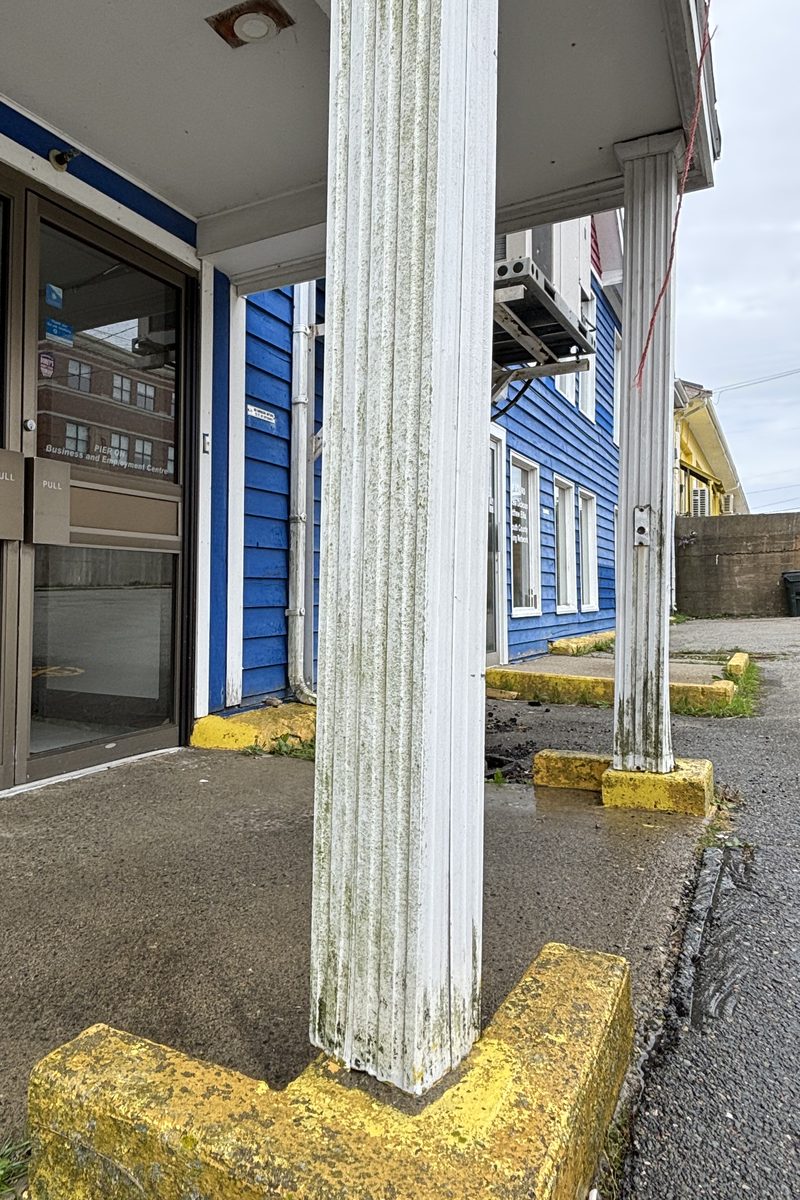 Entrance post at Pier One before washing, streaked green with algae